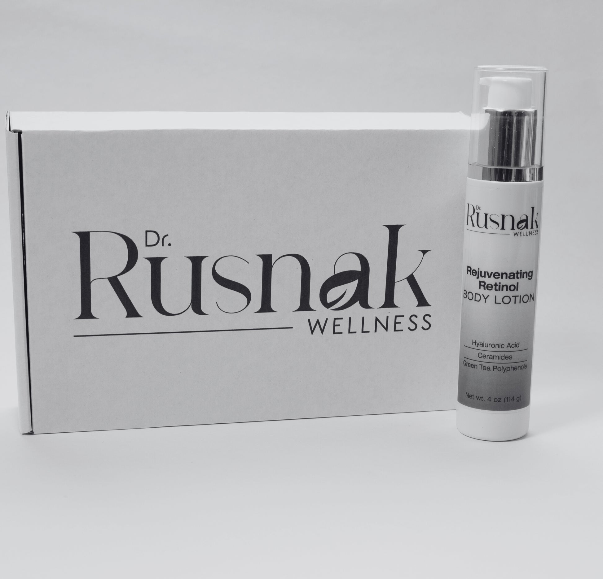 Dr Rusnak Wellness Anti-Aging Body Moisturizer with Retinol bottle with packaging on a gray background